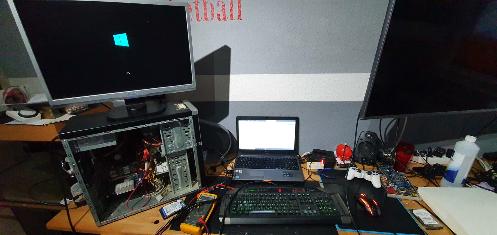 Erste Reparaturjobs: geöffneter PC, Laptop und Multimeter auf dem Schreibtisch
