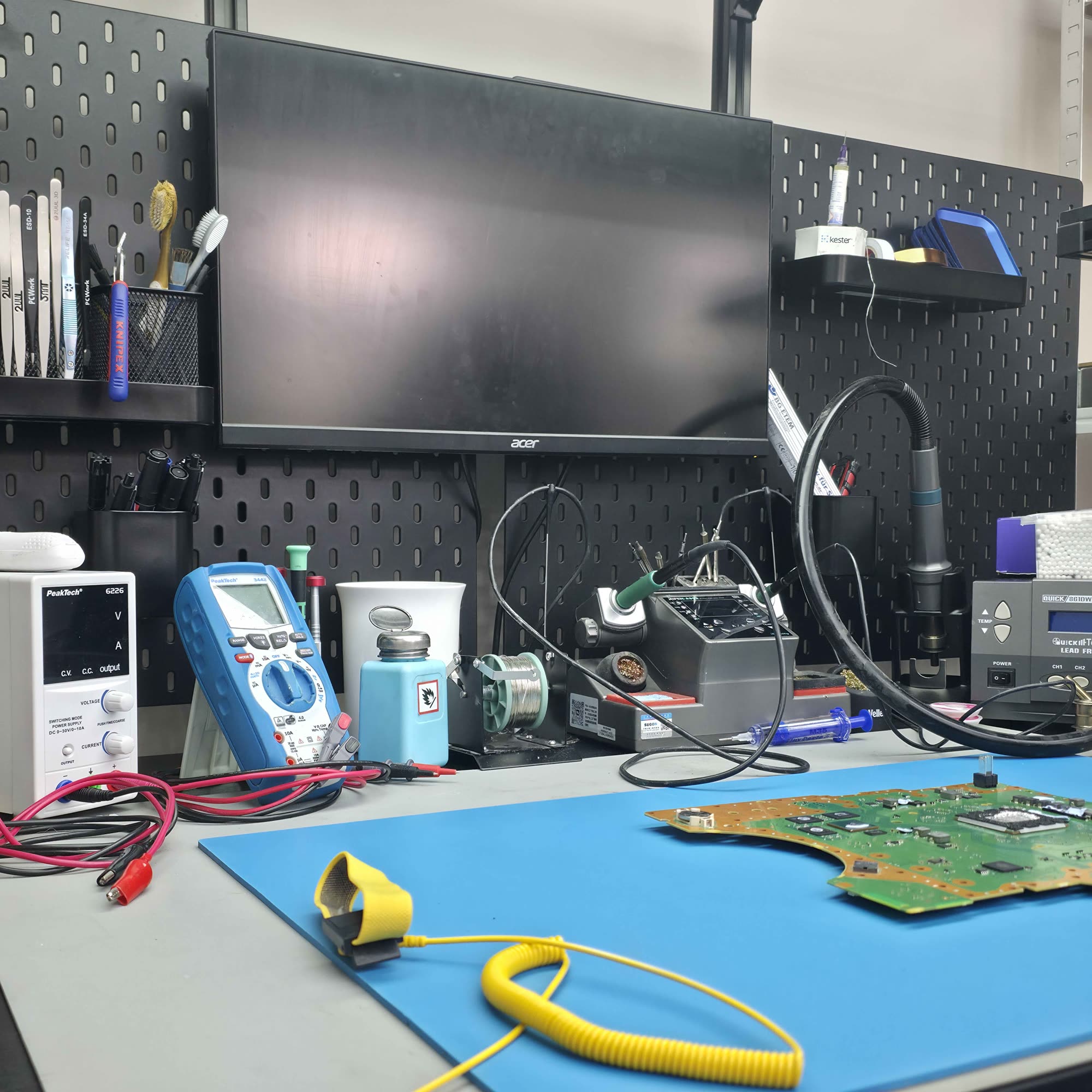 ESD-Arbeitsplatz bei FairTech mit Lötstation, Netzteil und PS4-Mainboard